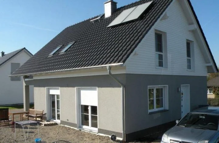 Fertiggestelltes Einfamilienhaus mit grauer Putzfassade
