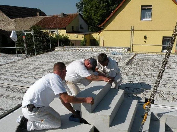 Handwerker setzen Deckenelemente auf dem Rohbau