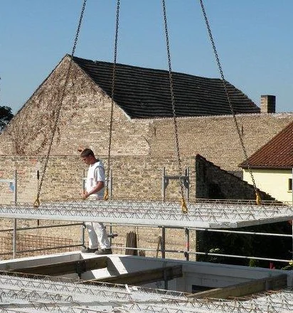 Mitarbeiter von Kitzing Bau verlegen Deckenelemente auf einem Rohbau